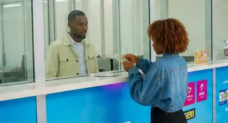 Un agent de SIM Global Transaction sert une cliente au guichet de l'agence